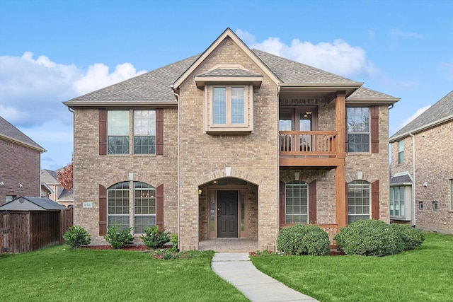 view of front of house with a balcony and a front yard