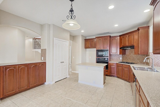 kitchen with decorative backsplash, sink, black appliances, a center island, and hanging light fixtures