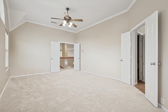 unfurnished bedroom featuring carpet floors, crown molding, ceiling fan, and lofted ceiling