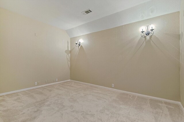 carpeted empty room featuring lofted ceiling and a textured ceiling