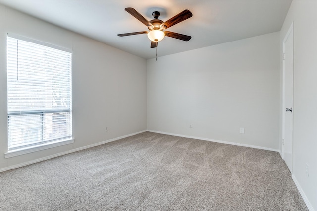 empty room featuring light colored carpet, ceiling fan, and a healthy amount of sunlight