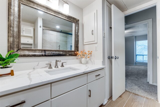 bathroom with vanity, wood-type flooring, and walk in shower