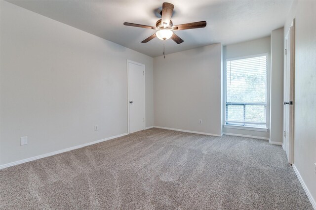 unfurnished room with ceiling fan and carpet