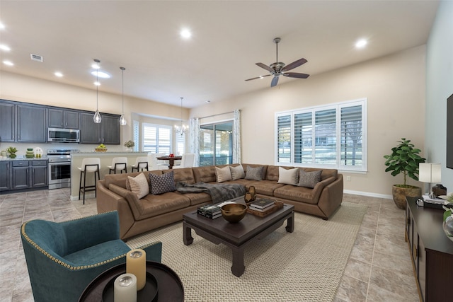 living room with ceiling fan with notable chandelier