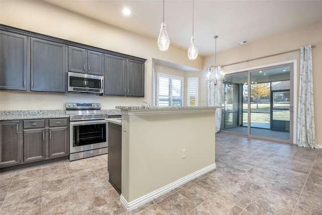 kitchen featuring pendant lighting, appliances with stainless steel finishes, light stone countertops, and dark brown cabinets