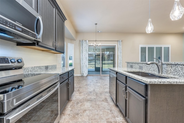 kitchen with sink, decorative light fixtures, dark brown cabinets, and stainless steel appliances