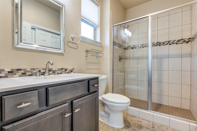 bathroom with vanity, tasteful backsplash, a shower with door, and toilet