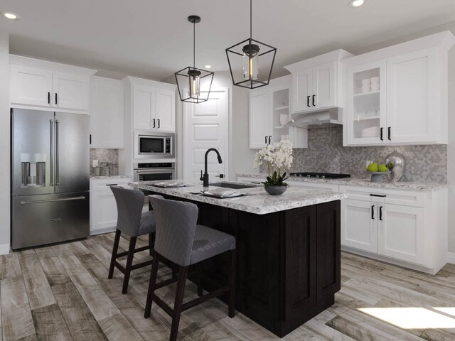 kitchen with white cabinetry, sink, stainless steel appliances, light hardwood / wood-style floors, and decorative backsplash