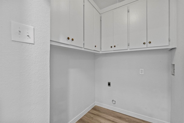 washroom featuring hookup for an electric dryer, cabinets, light wood-type flooring, and hookup for a washing machine