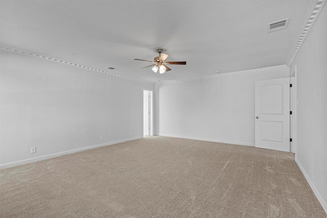 unfurnished room with crown molding, a ceiling fan, visible vents, and light colored carpet