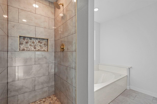 bathroom featuring tile patterned flooring and shower with separate bathtub