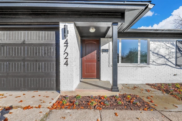 view of exterior entry featuring brick siding