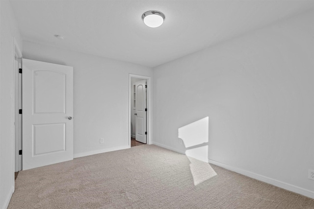 unfurnished room featuring baseboards and carpet flooring