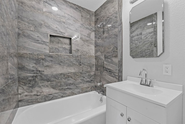 bathroom with vanity and tiled shower / bath