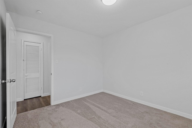 spare room featuring carpet flooring and baseboards