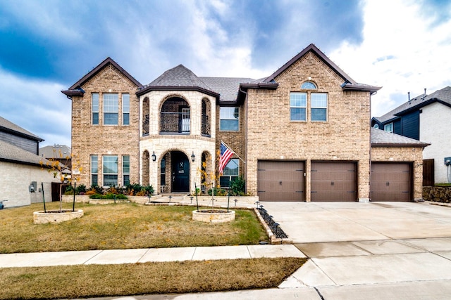 view of front of home featuring a balcony, a front lawn, and a garage