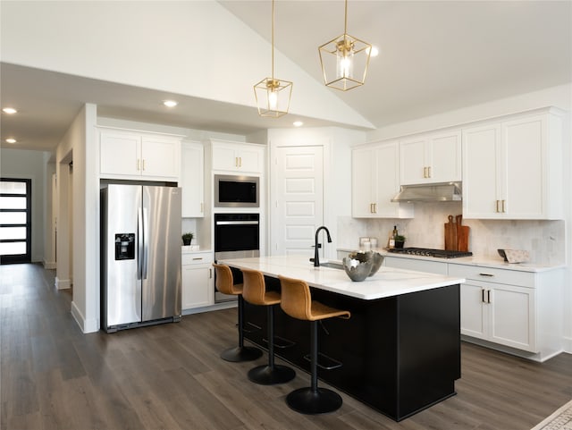 kitchen with white cabinetry, a kitchen island with sink, lofted ceiling, and appliances with stainless steel finishes