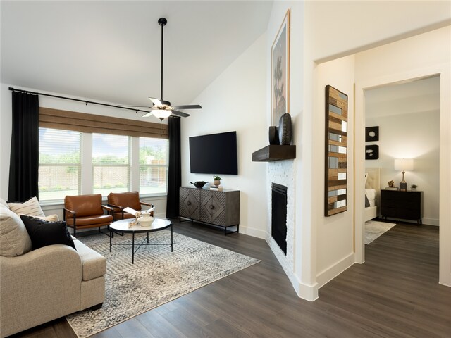 living room with dark hardwood / wood-style floors, ceiling fan, and vaulted ceiling