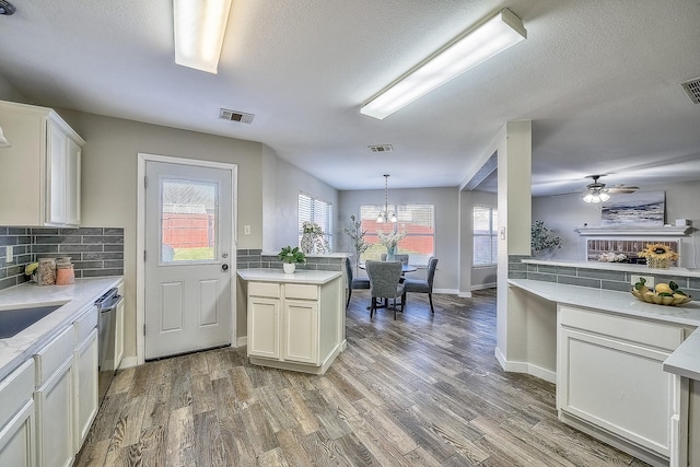 kitchen with pendant lighting, dark hardwood / wood-style floors, kitchen peninsula, and white cabinets