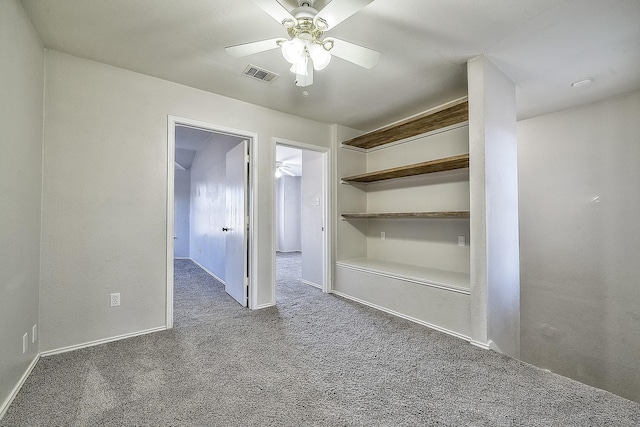 unfurnished room with ceiling fan and dark colored carpet