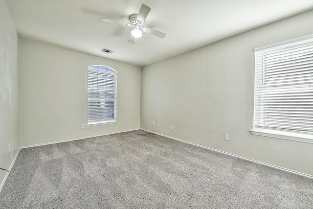 carpeted empty room with ceiling fan and a textured ceiling