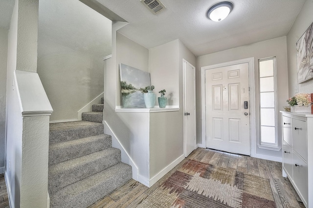 foyer entrance featuring a textured ceiling