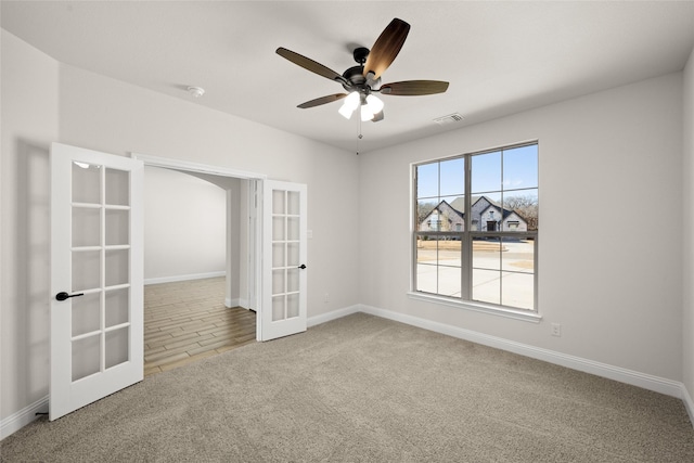 unfurnished room featuring a ceiling fan, french doors, visible vents, baseboards, and carpet flooring