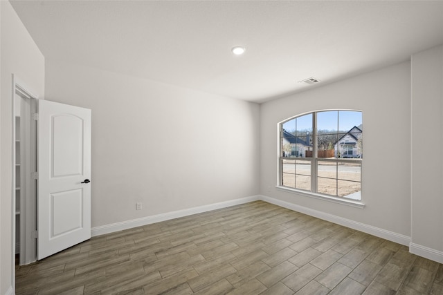 unfurnished room featuring visible vents, recessed lighting, baseboards, and wood finished floors