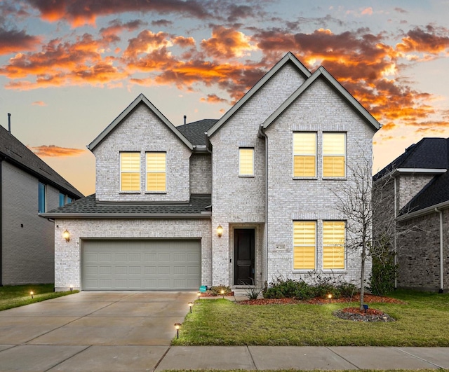 view of front of home with a garage and a yard