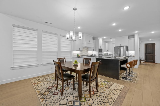 dining room with an inviting chandelier and light wood-type flooring