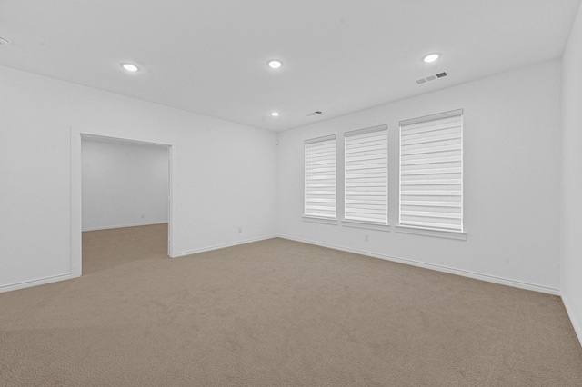 spare room featuring light colored carpet