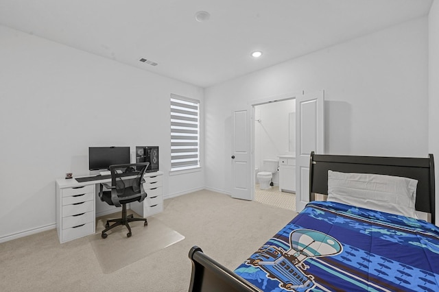 bedroom featuring light colored carpet and ensuite bathroom