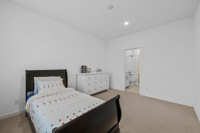 bedroom with connected bathroom and light colored carpet