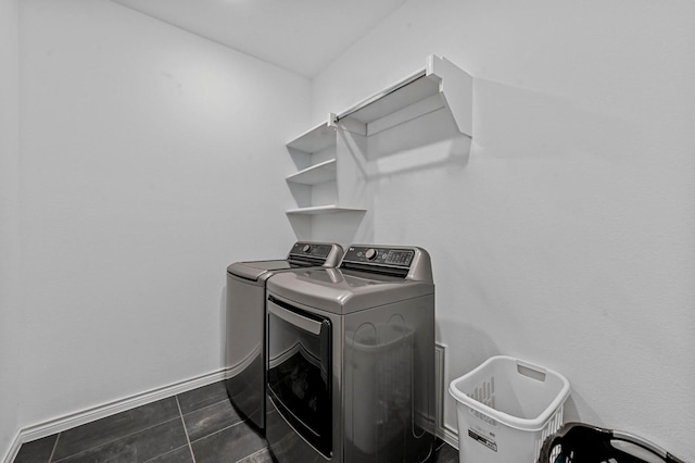 clothes washing area with washing machine and dryer and dark tile patterned flooring