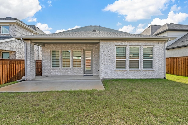 rear view of house featuring a yard and a patio