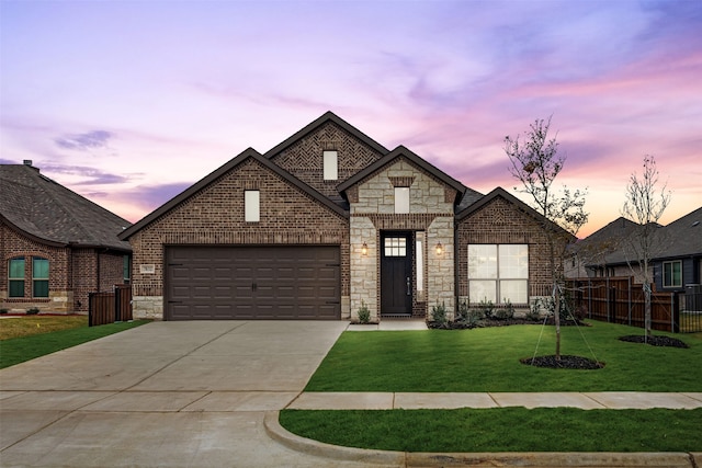 view of front of property with a garage and a lawn