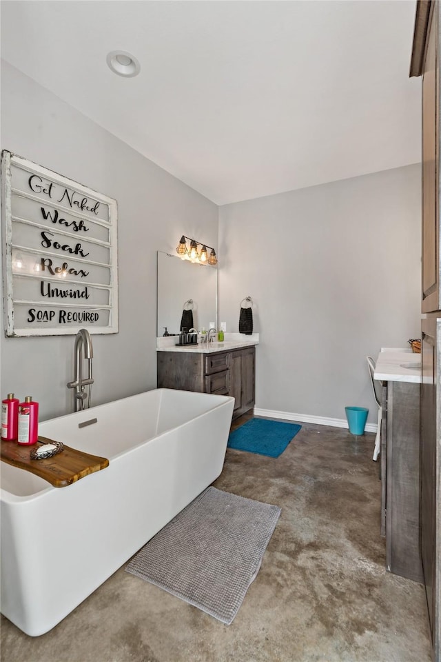 bathroom featuring vanity, a bathtub, and concrete floors