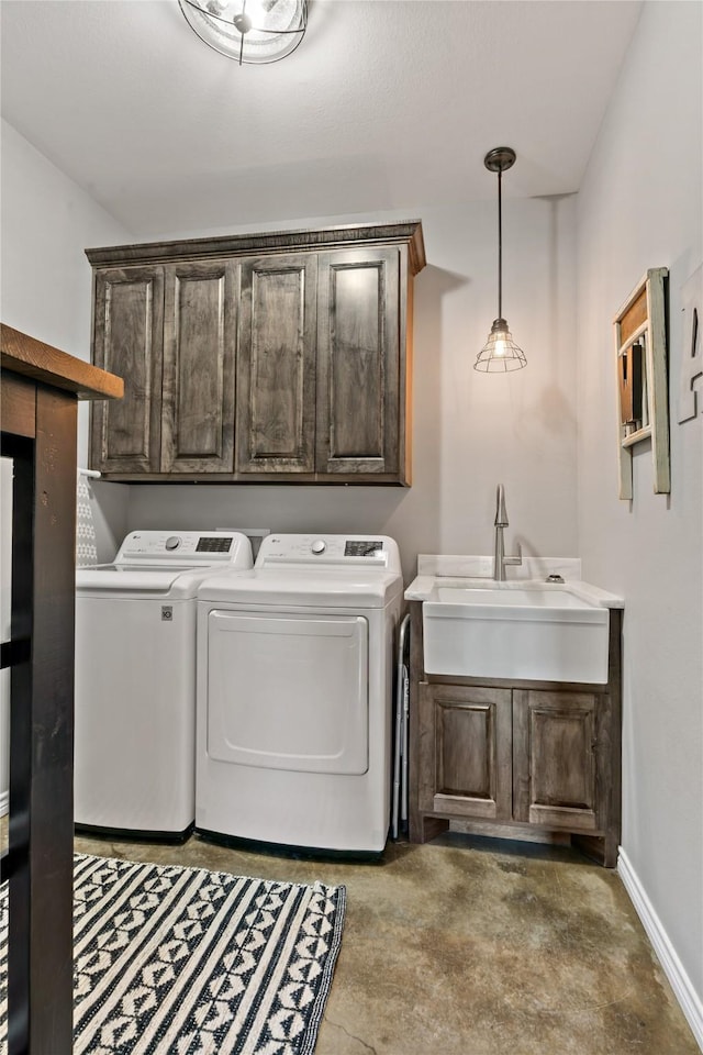 clothes washing area featuring cabinets, sink, and washing machine and dryer