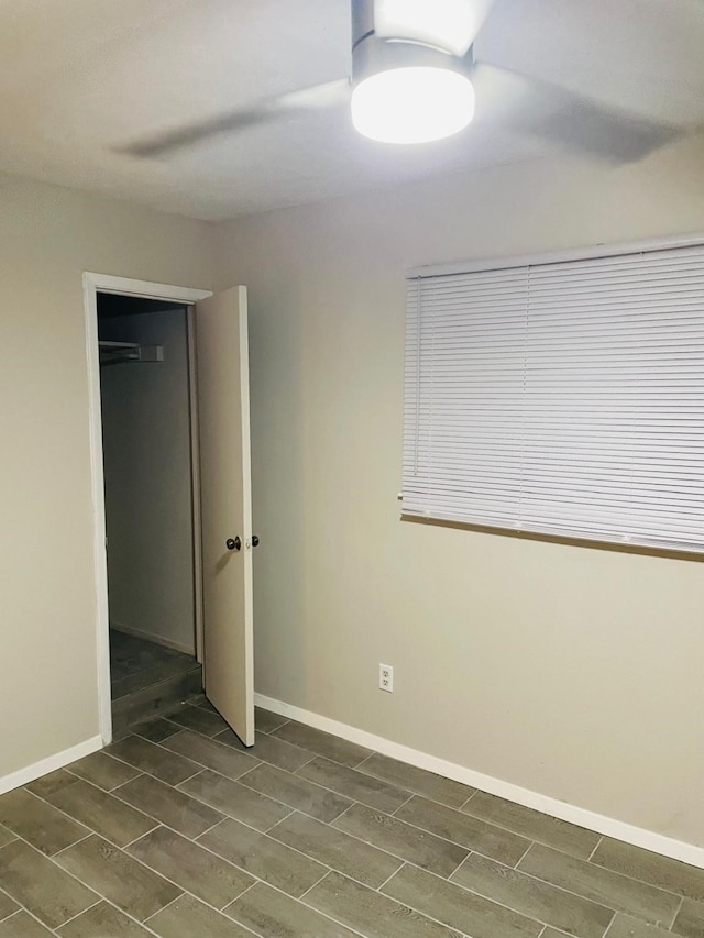 unfurnished bedroom featuring ceiling fan and dark hardwood / wood-style flooring