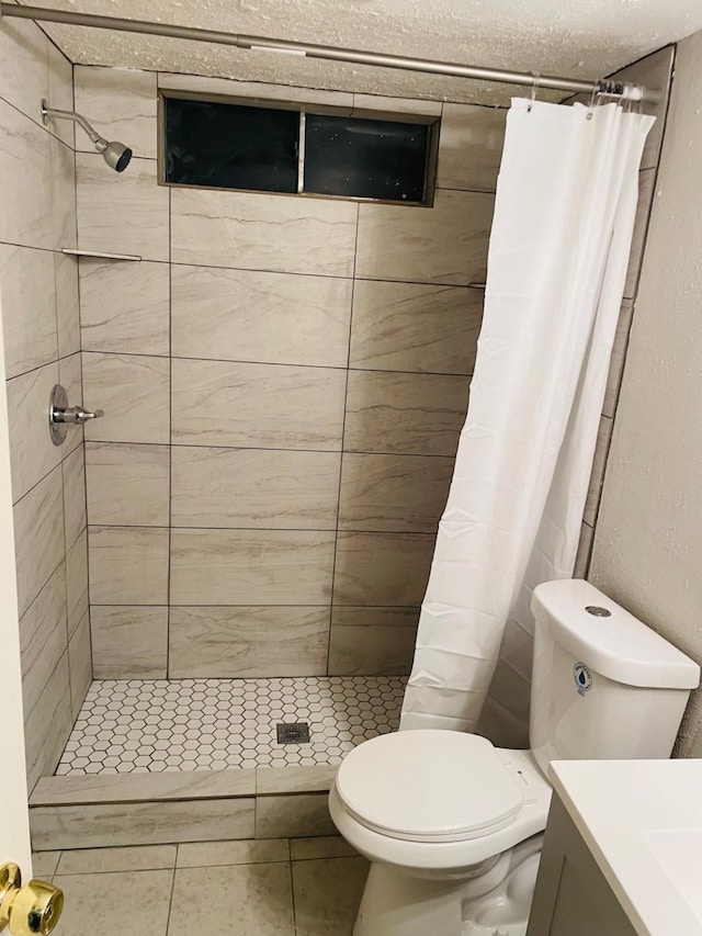 bathroom featuring tile patterned floors, vanity, a shower with shower curtain, and toilet