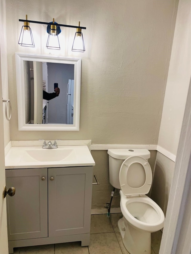 bathroom featuring tile patterned floors, vanity, and toilet