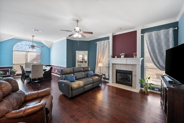 living room with a tiled fireplace, vaulted ceiling, hardwood / wood-style floors, and ceiling fan