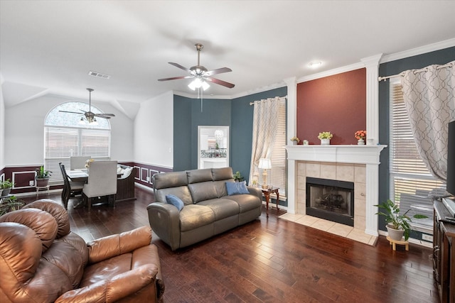 living room featuring a tile fireplace, lofted ceiling, ceiling fan, hardwood / wood-style floors, and ornamental molding