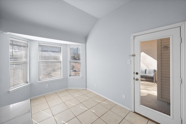 empty room featuring light tile patterned flooring and lofted ceiling