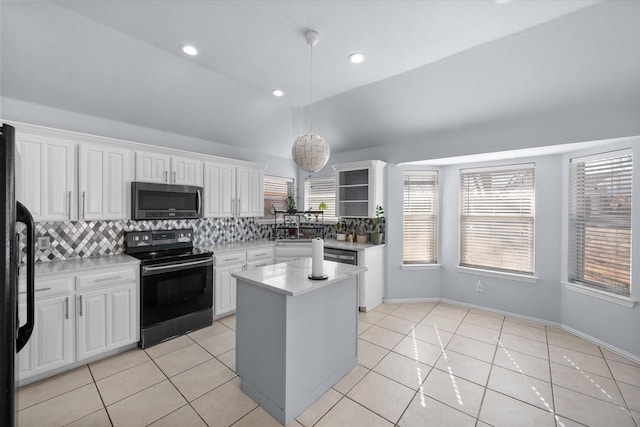 kitchen featuring white cabinetry, tasteful backsplash, range with electric stovetop, and a center island