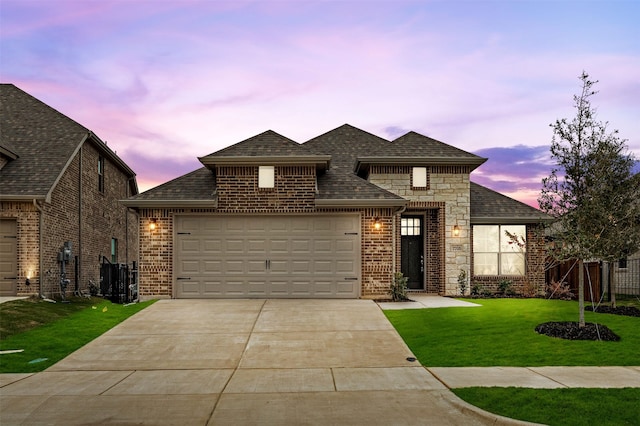 view of front of house with a garage and a yard