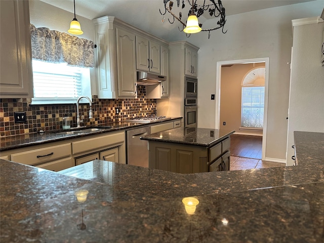 kitchen featuring gray cabinets, dark stone countertops, stainless steel appliances, and decorative light fixtures