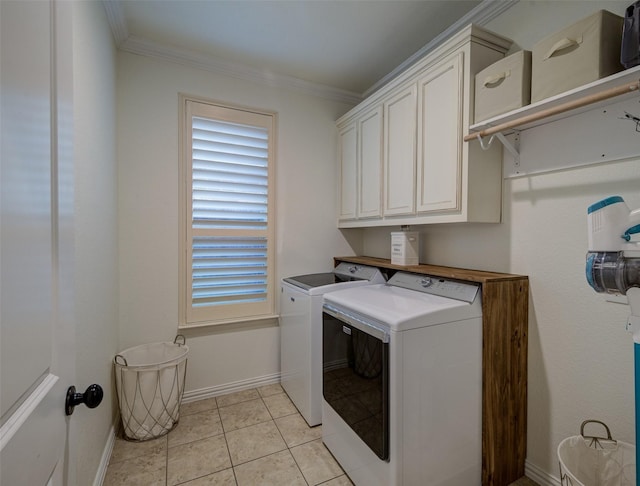 laundry room featuring light tile patterned flooring, cabinets, washer and dryer, and ornamental molding