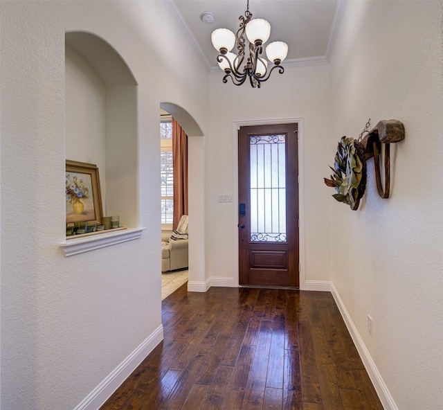 foyer featuring a chandelier, dark hardwood / wood-style flooring, and crown molding