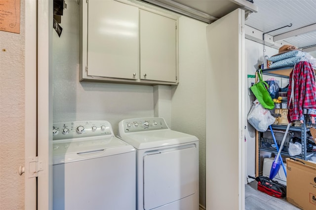 laundry area with washer and dryer, cabinets, and light hardwood / wood-style flooring